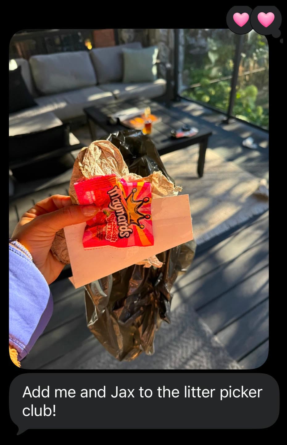 A text from a friend with a photo of a candy wrapper and litter held on a sunny deck, reading “Add me and Jax to the litter picker club!”